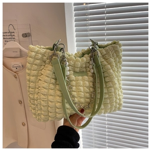 Detail of light green popcorn texture tote bag with pearl and metal flower chain