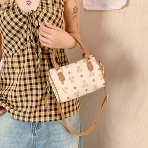 Close-up of a mini Boston bag with bear patterns, leather handles and gold hardware