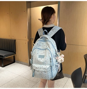 Detail of light blue backpack with star patterns and cute white bunny plush accessory