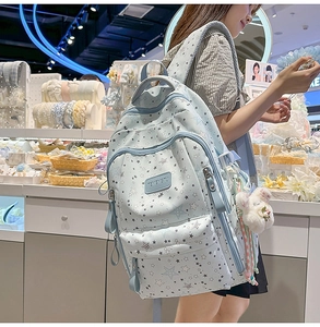 Detail of light blue starry backpack with cute plush rabbit charm and star patterns