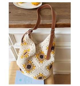 Detailed close-up of woven sunflower tote bag with brown leather strap and silver buckle