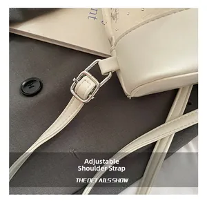 Detail of adjustable white leather strap with silver buckle on a lace bucket backpack