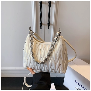 Detailansicht der weißen gesteppten Ledertasche mit Strasssteinen und Silberkette