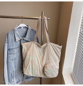 Détail du sac cabas en toile crème avec motif chat vert et petite pochette ronde amovible
