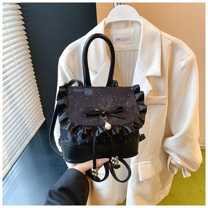Detail of black gothic lace backpack with satin bow, ruffles and pearl pendant decor