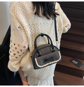 Close-up of grey tweed shell bag with black bow detail and white lace trim on stairs