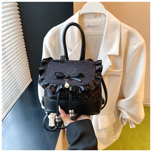 Detail of black mini lace backpack with bow, pearl pendant and velvet polka dots