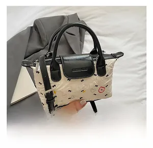 Dettaglio della borsa a bauletto con stampa a fiocchi e manici in pelle nera chic