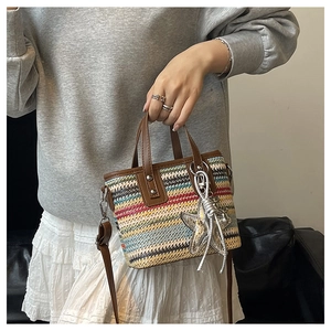 Detail of colorful woven rainbow striped handbag with leather handle and star charm
