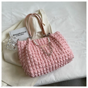 Detail of pink bubble textured tote bag featuring pearl and metal chain straps
