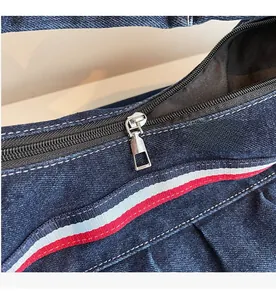 Close-up of smooth silver zipper and striped ribbon detail on a blue nylon bag