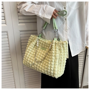 Detail of light green bubble texture tote bag with elegant pearl and chain handle