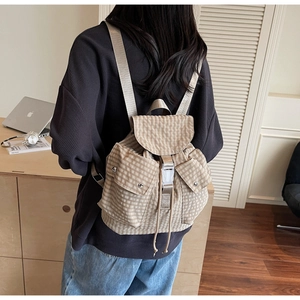 Detailansicht des karierten Rucksacks mit Kordelzug und weißen Steckschnallen