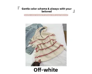 Flat lay of creamy white knitted tote bag with red wave patterns and tassel detail