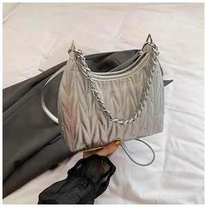 Detailansicht der silbernen Stepptasche mit Kettenhenkel und Diamant-Nietendekor