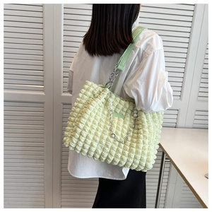Detail of light green bubble textured tote bag with elegant pearl and metal chain straps