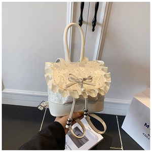 Detail of cream balletcore mini backpack featuring lace trim, bow and pearl pendant