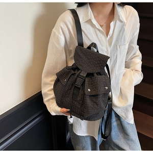 Detailansicht eines schwarz-weißen Karo-Rucksacks mit Schnallenverschluss und Taschen