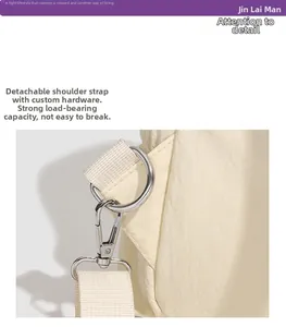 Detail of detachable shoulder strap with silver swivel hook on cream nylon backpack