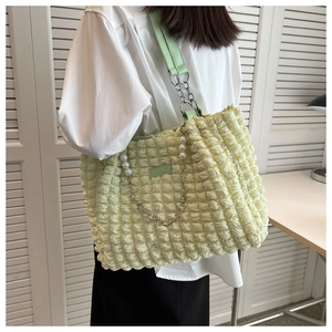 Detail of light green bubble texture tote bag with pearl pendant and chain strap
