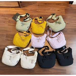 Detailed macro view showing diverse color options and textured nylon fabric of the bags