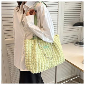 Detail of light green popcorn texture tote bag with pearl chain shown in lifestyle setting