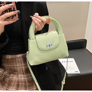 Detail of light green mint crossbody bag with silver twist lock and vertical textured pattern