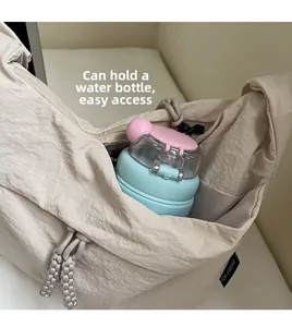 Detail view of the spacious inner compartment showing a water bottle inside a beige bag