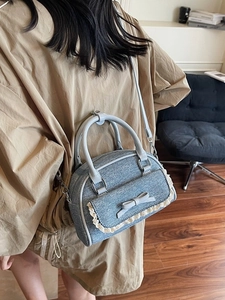 Blue denim ballet shell bag with lace trim and bow detail shown on models outfit