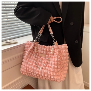 Detail of pink bubble texture tote bag with pearl charms and stylish metal chain strap