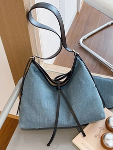 Denim tote bag with black leather straps and large capacity for daily commuting