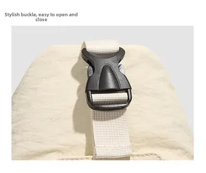 Detail of durable black plastic buckle on beige nylon strap with textured fabric