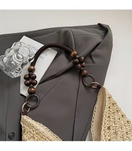 Detail of hand-woven straw tote with wooden bead shoulder strap and fabric lining