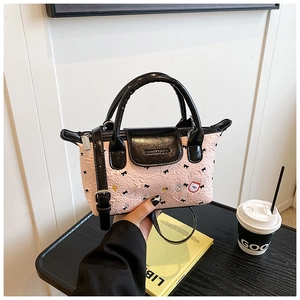 Dettaglio della borsa rosa plissettata con ricamo a fiocco nero e ciondoli a cuore
