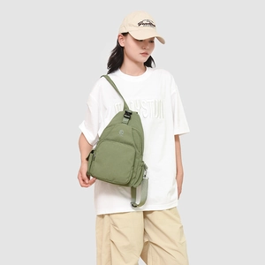 Olive green canvas chest bag detail showing front zipper pocket and adjustable strap