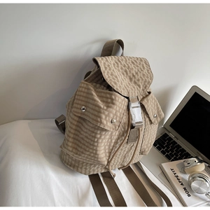 Detail eines karierten Canvas-Rucksacks mit Kordelzug und Schnallenverschluss