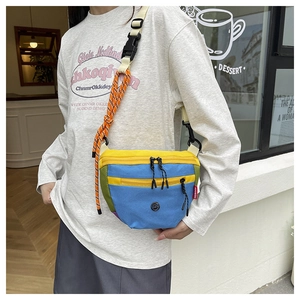 Dettaglio della borsa a tracolla in nylon color-block con tasche a zip e tracolla intrecciata