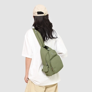 Detailed back view of an army green multi-pocket nylon sling bag on a model