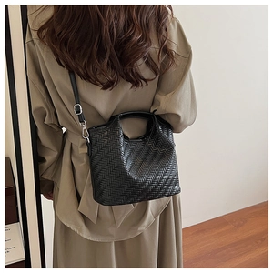 Detail of black woven texture handbag with silver hardware and detachable strap