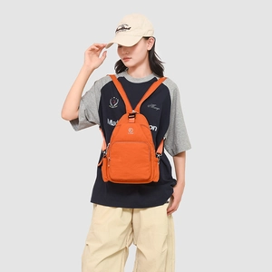 Detail of a bright orange nylon multifunctional chest bag with adjustable thin straps