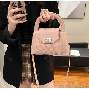Detail of pink pleated leather handbag with silver twist lock and adjustable strap