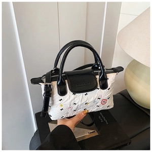 Dettaglio borsa a mano bianca a pieghe con ricamo orsetto e fiocchi neri decorativi