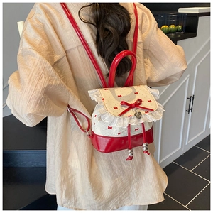 Close-up of ballet-style lace trim and red bow details on a sweet white backpack