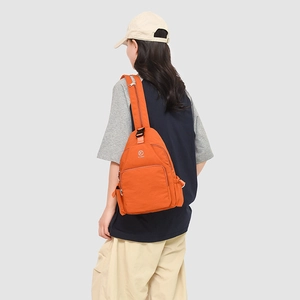Detail of the orange waterproof nylon sling bag with adjustable black buckle and zippers