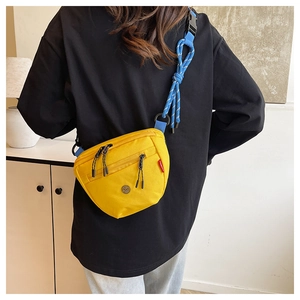 Dettaglio della borsa a tracolla in tela gialla con tracolla blu e tasche con zip