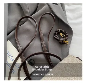 Détail du sac tissé beige avec bandoulière réglable marron et mousquetons dorés
