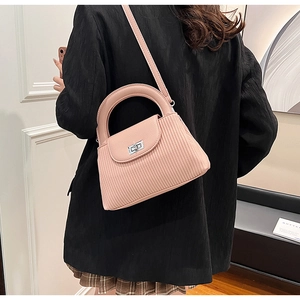 Detail of pink pleated crossbody bag with silver twist lock and round handle