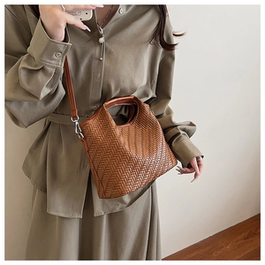 Close-up of brown woven handbag showing V-shaped texture and detachable shoulder strap