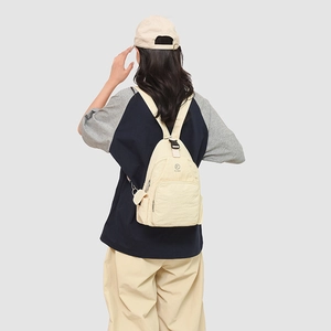 Detail of KULIBAO cream-white nylon mini backpack with anti-theft back zipper shown on model