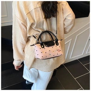 Dettaglio di una mini borsa rosa a tracolla con texture 3D e motivo a orso su un modello